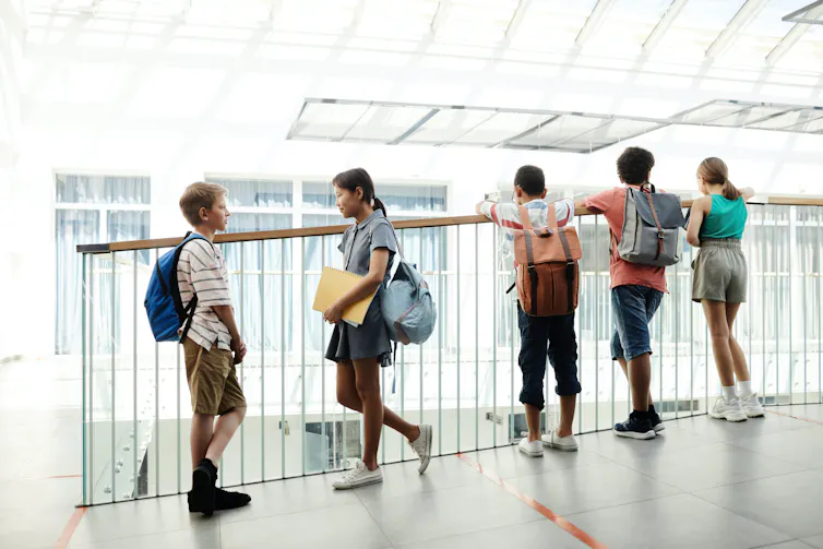 Students seen on a landing overlooking a foyer.