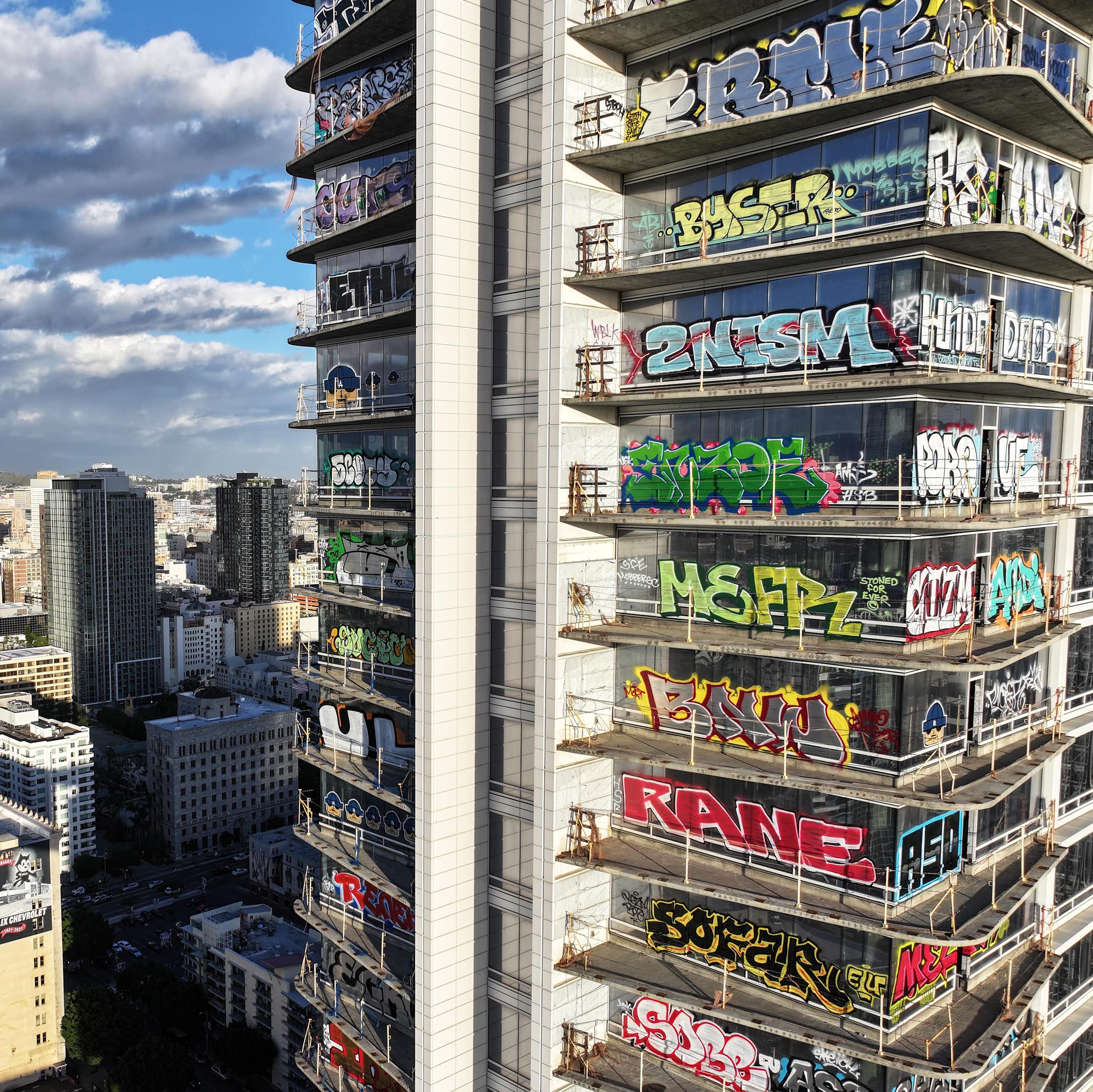 An aerial view of colorful graffiti on an unfinished skyscraper.