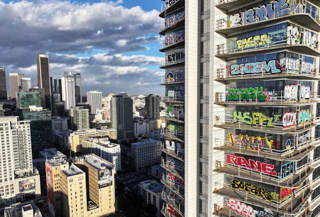 An aerial view of colorful graffiti on an unfinished skyscraper.