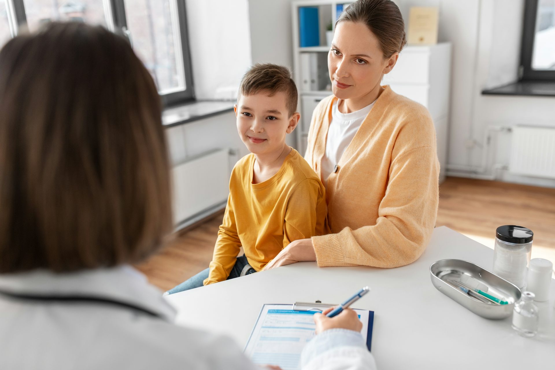 A mother and child and a doctor seen from behind