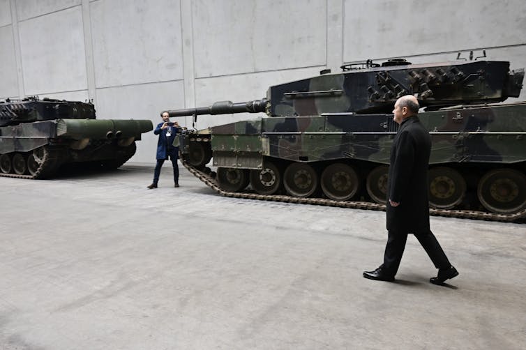 Un homme passe devant un char militaire.