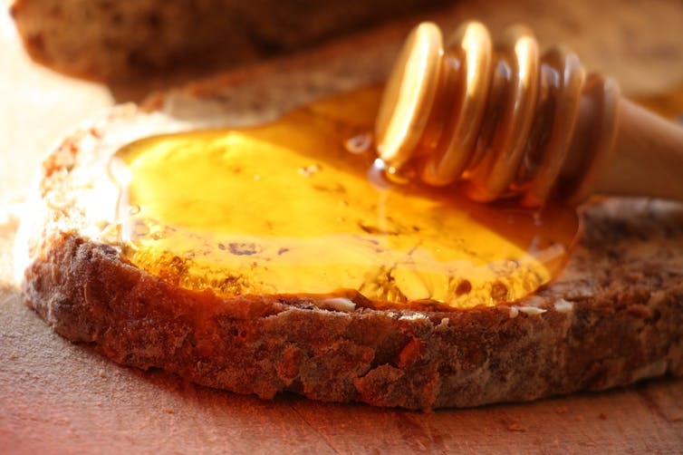 Close-up of a slice of bread with golden honey pooling on top