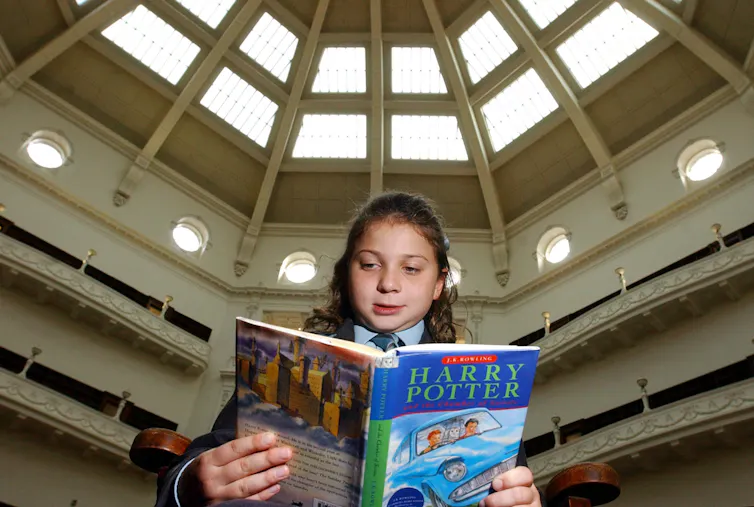 A girl reads the second Harry Potter book.