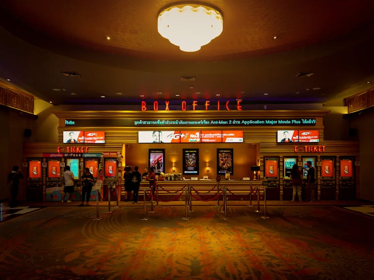 A ticket counter inside a movie theatre with 'Box Office' written in bright red letters