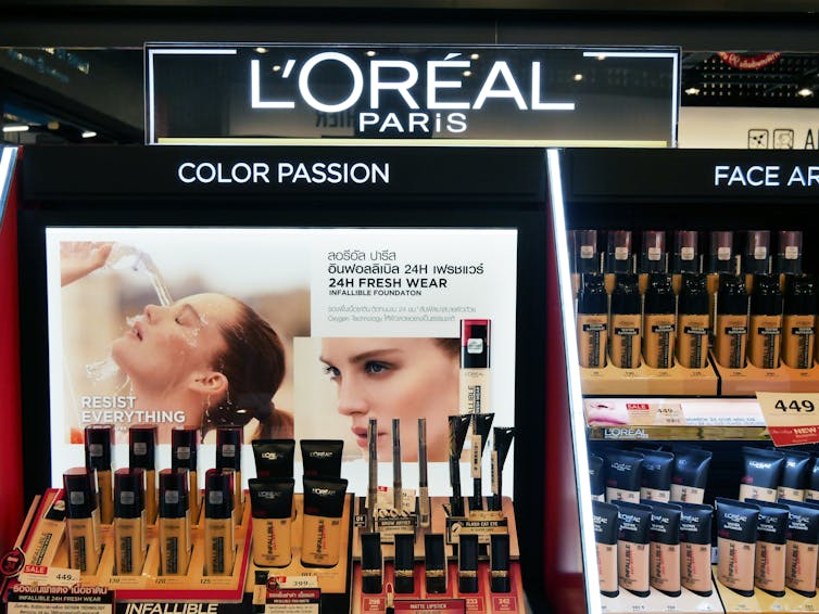 Image of a lipsticks, foundation and other make up on a product stand in a department store
