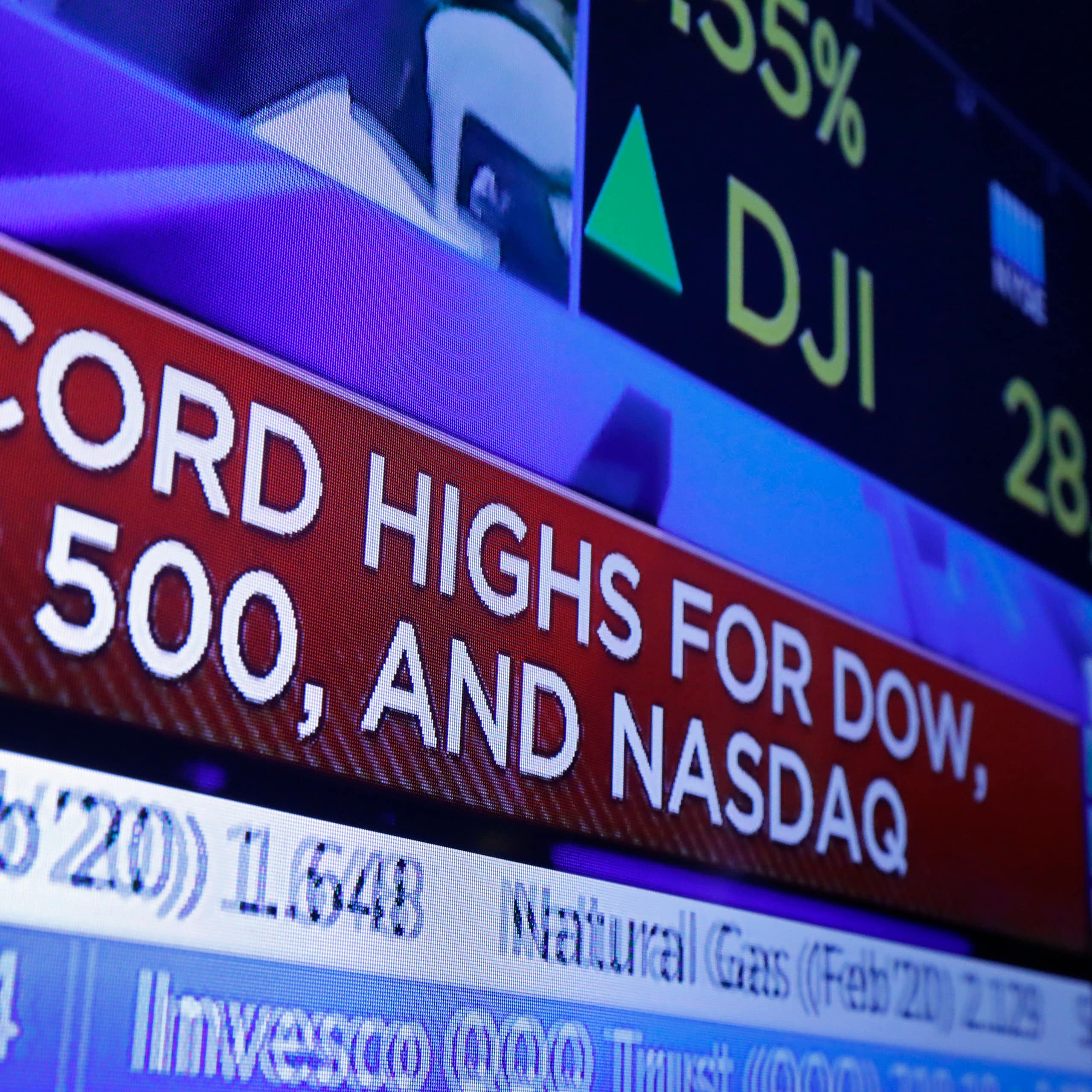 A television screen with headlines about stock market activity