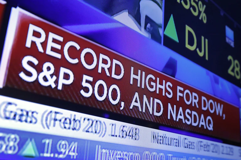 A television screen with headlines about stock market activity