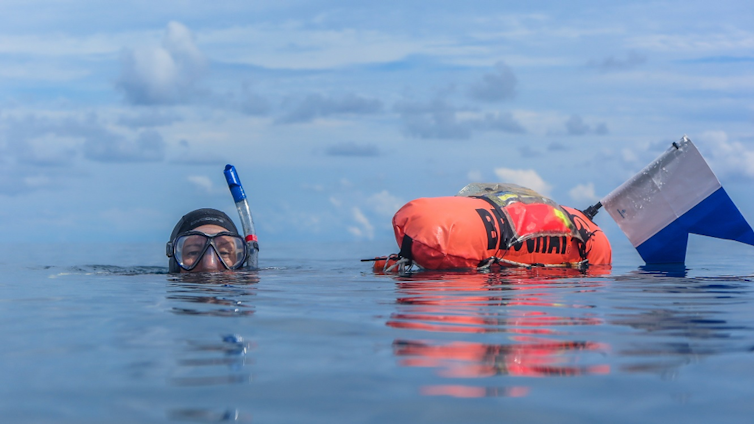 Researcher towing a GPS on  Great Barrier Reef during an expedition.