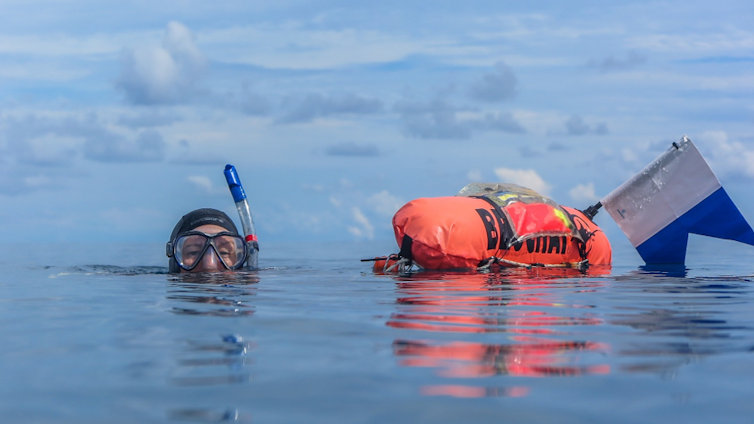 Researcher towing a GPS on Great Barrier Reef during an expedition.