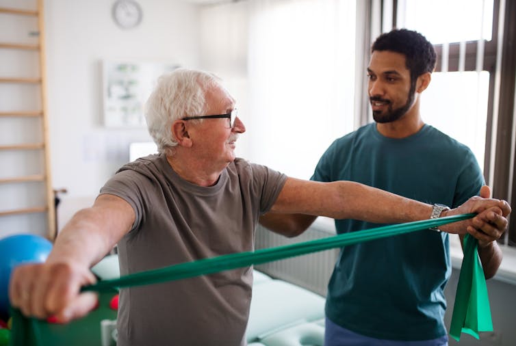 Physio helps patient use an exercise strap