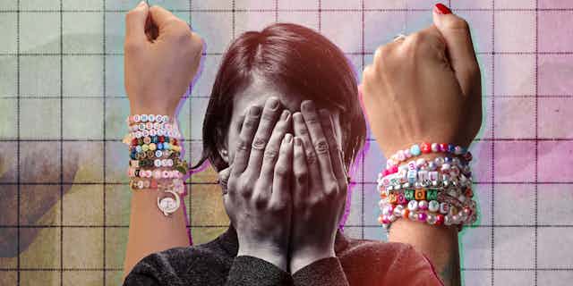 A woman with her head in her hands with two arms with friendship bracelets in the background