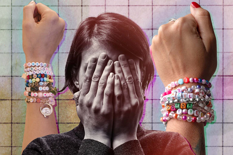 A woman with her head in her hands with two arms with friendship bracelets in the background