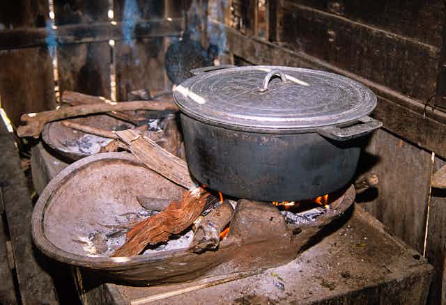A pot sitting on a wood fire