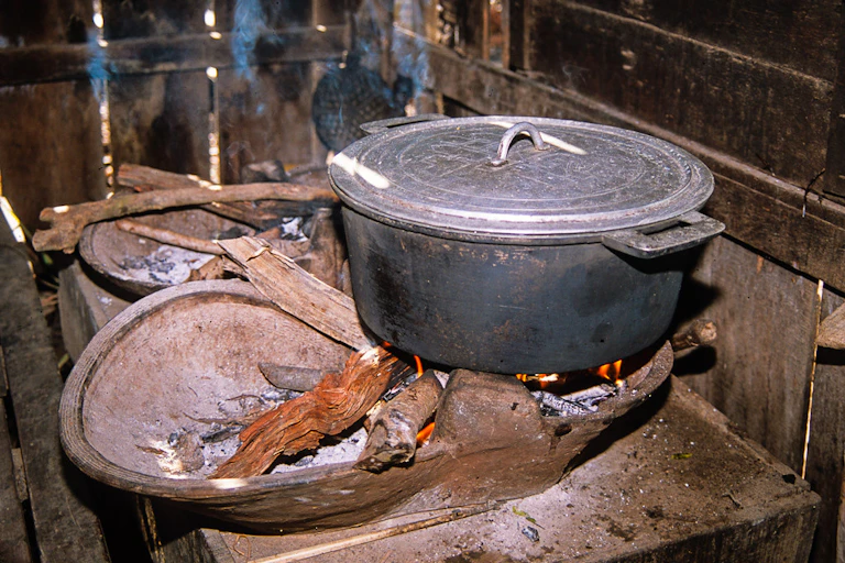 A pot sitting on a wood fire