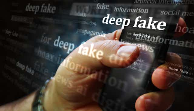 A concept image featuring a hand scrolling through a cellphone while the words deepfake, disinformation and fake news appear on a bigger screen behind the phone