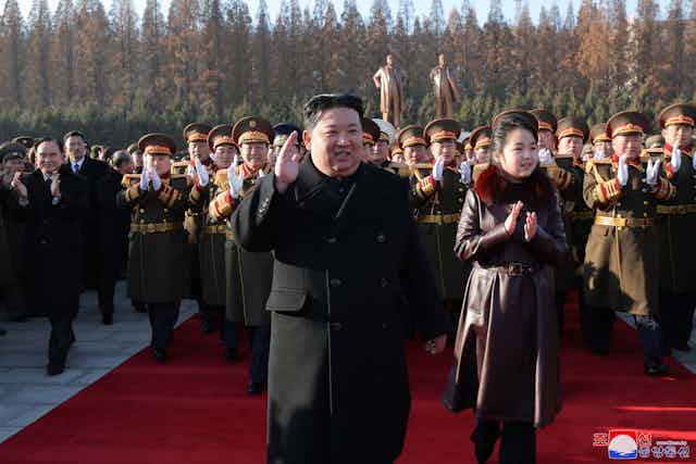 North Korean leader Kim Jong-un with his daughter Kim Ju-ae and a crowd of army officers.