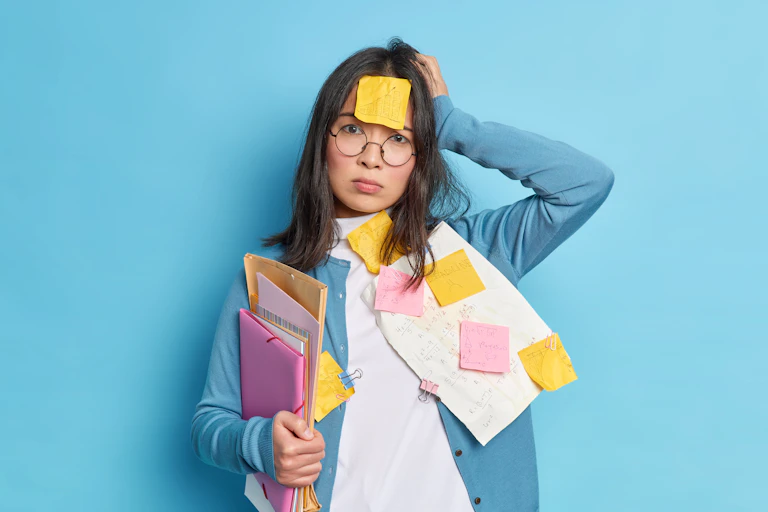 Forgetful woman covered in post-it notes and papers.