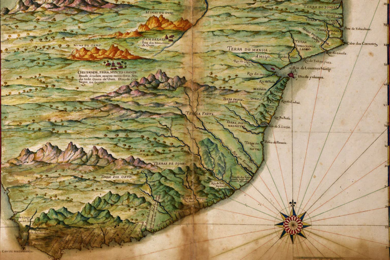 An old map in colour with cursive names in Portuguese showing a coastline and hilly interior.