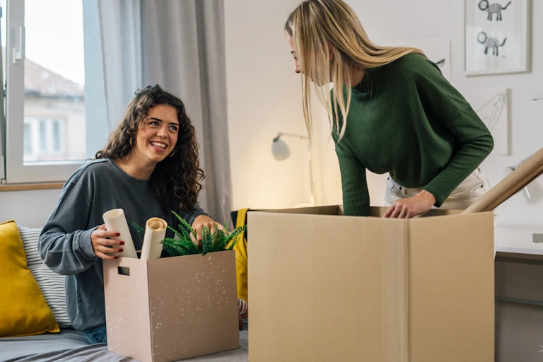 Jeunes femmes rangeant des affaires dans des caisses