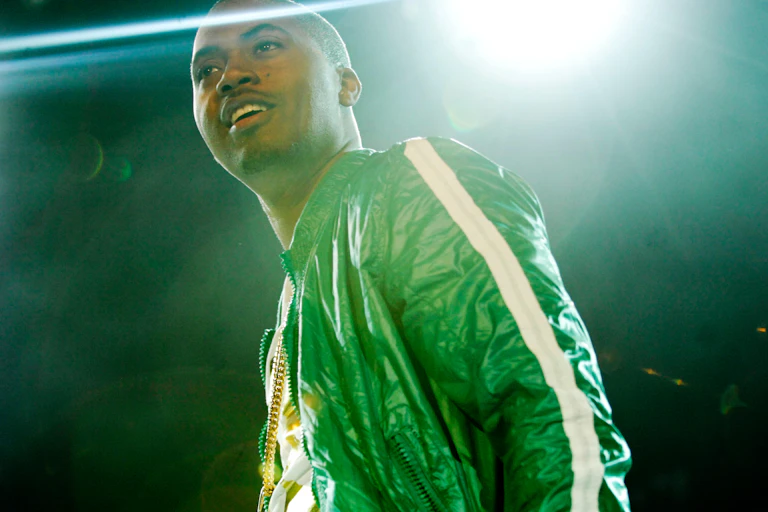 Nas on stage in a green jacket