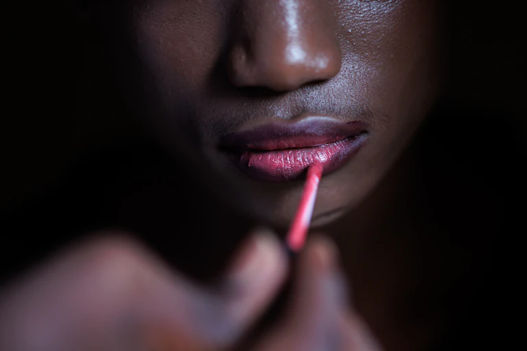 Una joven se pinta los labios.