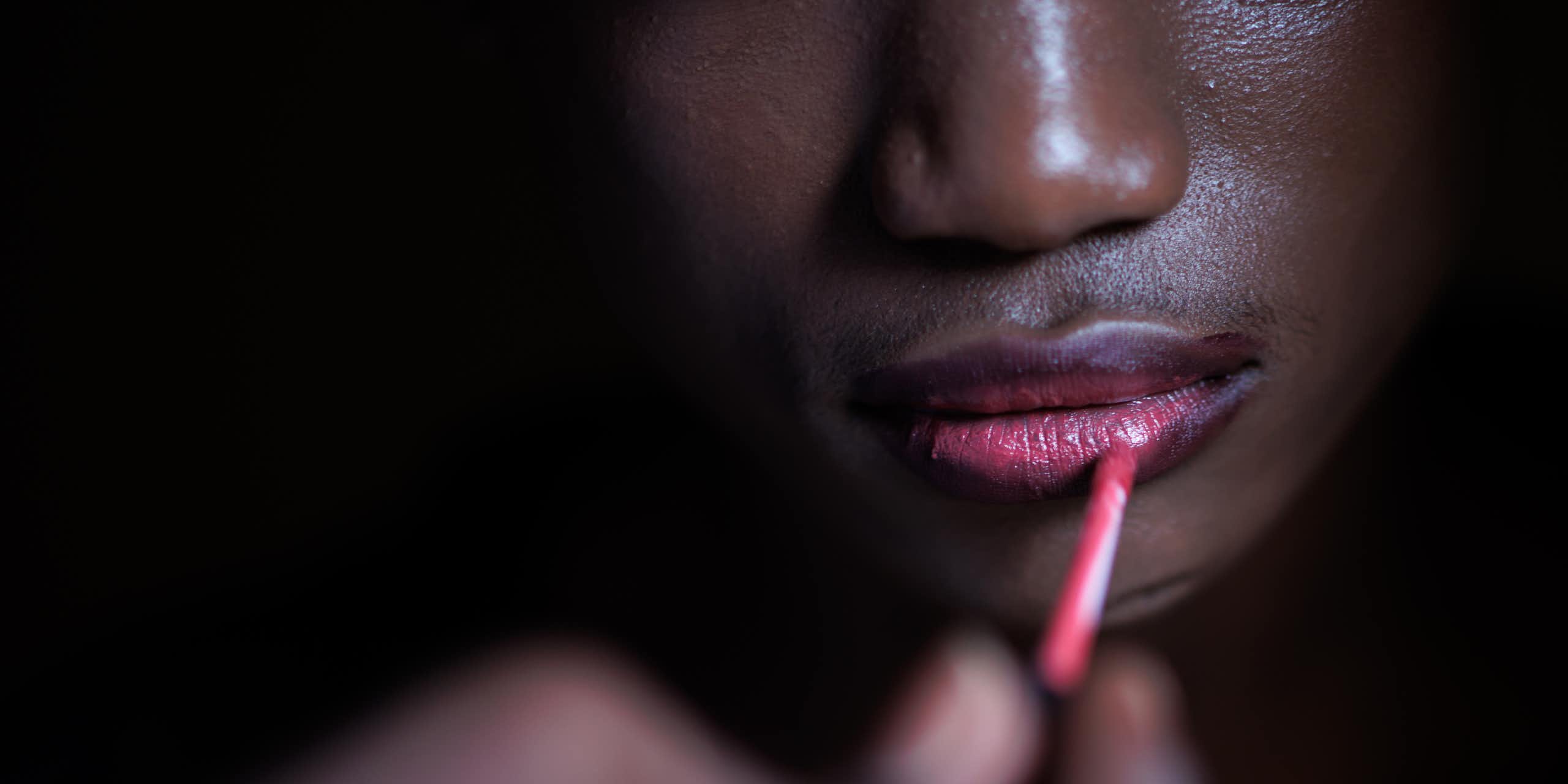 Una joven se pinta los labios.