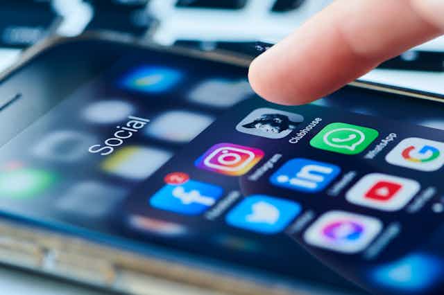 A finger hovering over social media apps on a smartphone