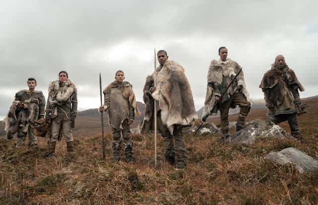 Six prehistoric humans in furs with spears
