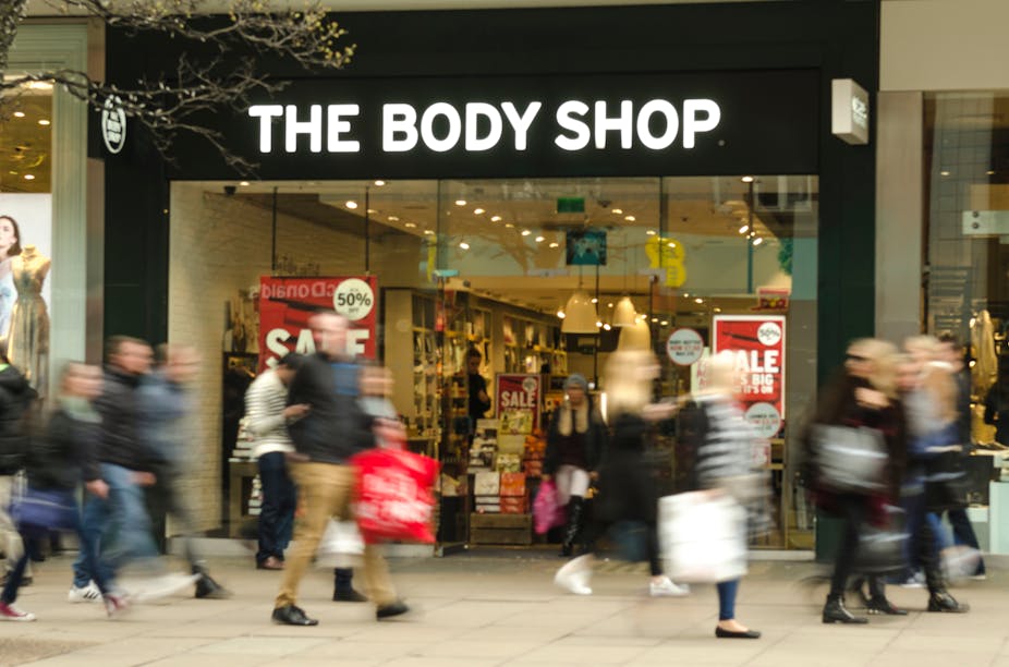 Shoppers passing branch of The Body Shop.