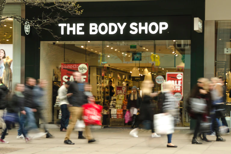 Shoppers passing branch of The Body Shop.
