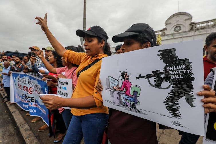 Women holding placards during a protest against the online safety act.