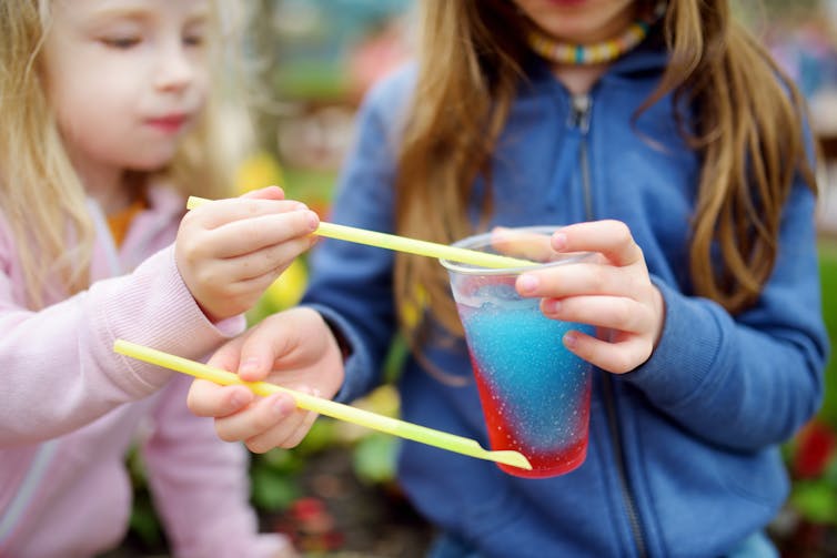 Two girls share a slushy