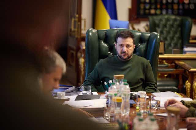 Ukrainian president Volodymyr Zelesnsky sitting at his desk.