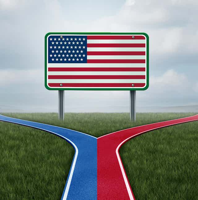 An American flag is painted on a billboard in a field, with blue and red paths leading away from it.