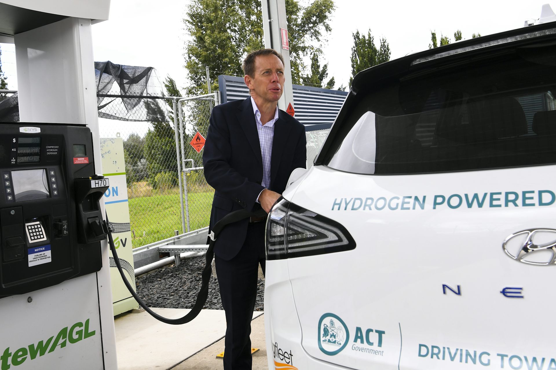 A man fills up a hydrogen-powered vehicle