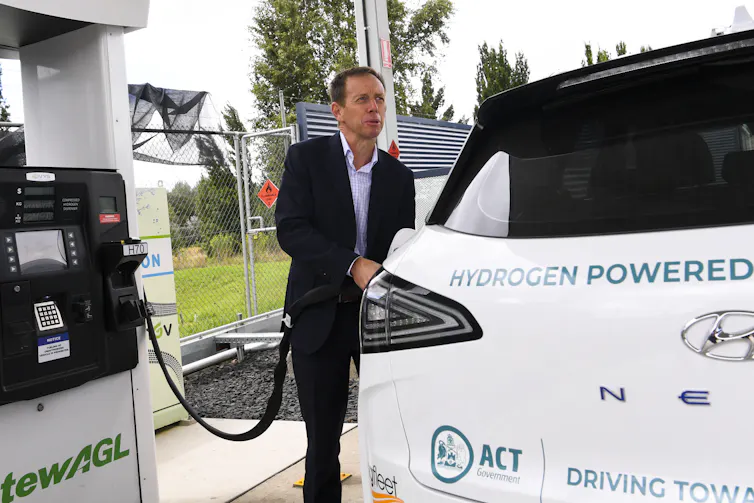 A man fills up a hydrogen-powered vehicle