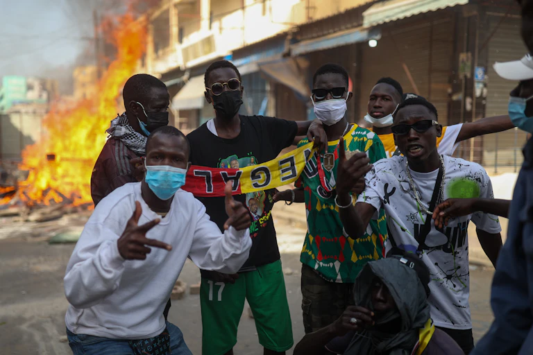 People demonstrating while burning items in the background