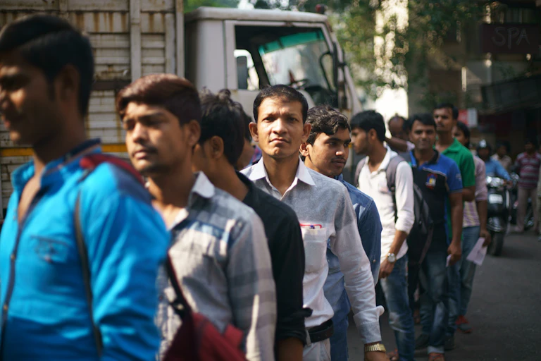 Workers standing in a line waiting for their day's work to begin.
