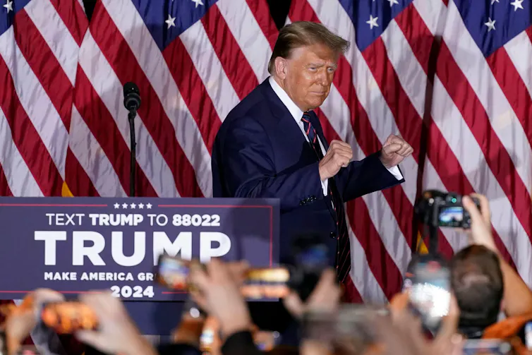 Donald Trump in front of some American flags