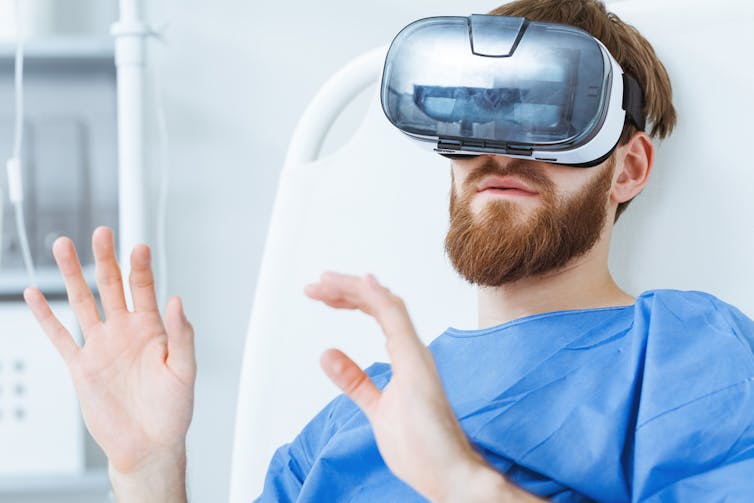 A younger man uses VR in hospital.