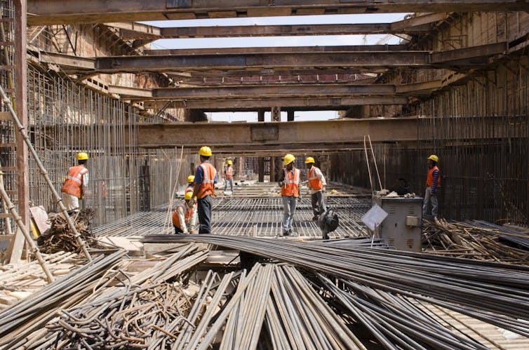 A group of workers in hi-vis jackets at a construction site.