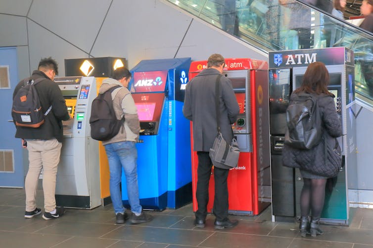 Customers stand outside Australian bank ATMs