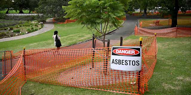 Victoria Park, where bonded asbestos was found in mulch, in Sydney, Wednesday, February 14, 2024, showing fenced off mulch around trees with a "Danger Asbestos" warning sign
