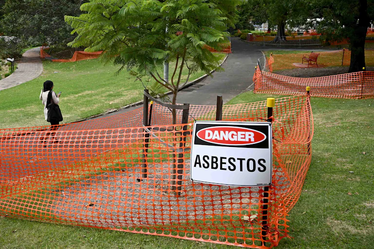 Victoria Park, where bonded asbestos was found in mulch, in Sydney, Wednesday, February 14, 2024, showing fenced off mulch around trees with a "Danger Asbestos" warning sign