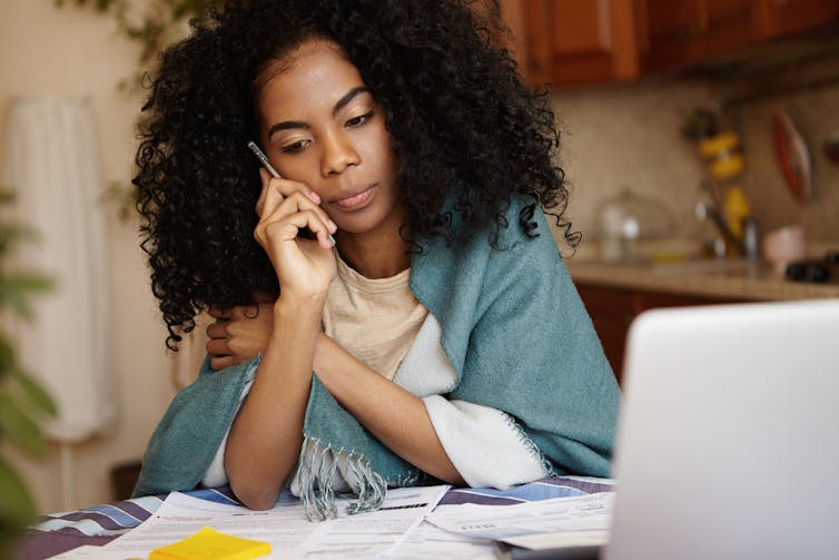 A woman with dark curly hair listening to someone on the phone