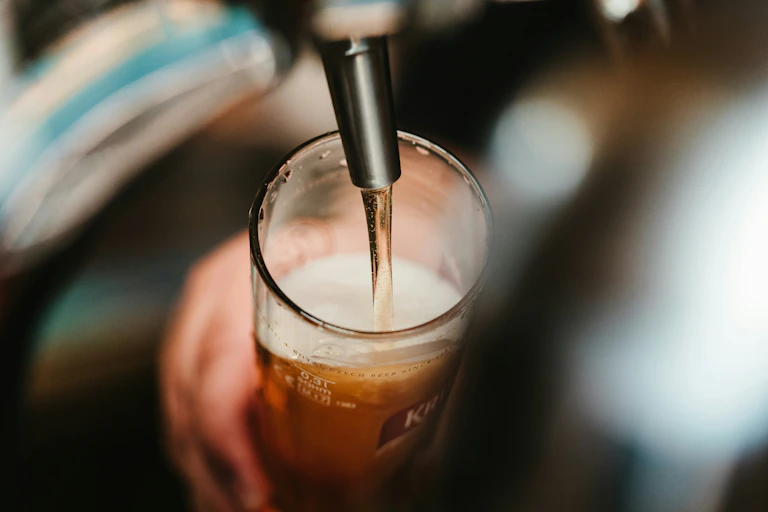 Photographie d'une bière qui coule dans un verre.