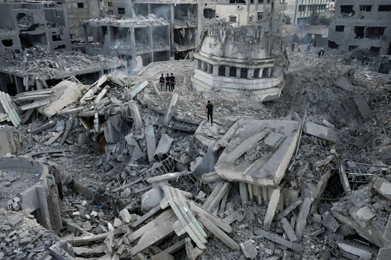people walk across a huge site of debris