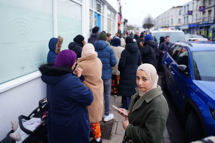 People in Bristol queueing to get registered at a dental practice.