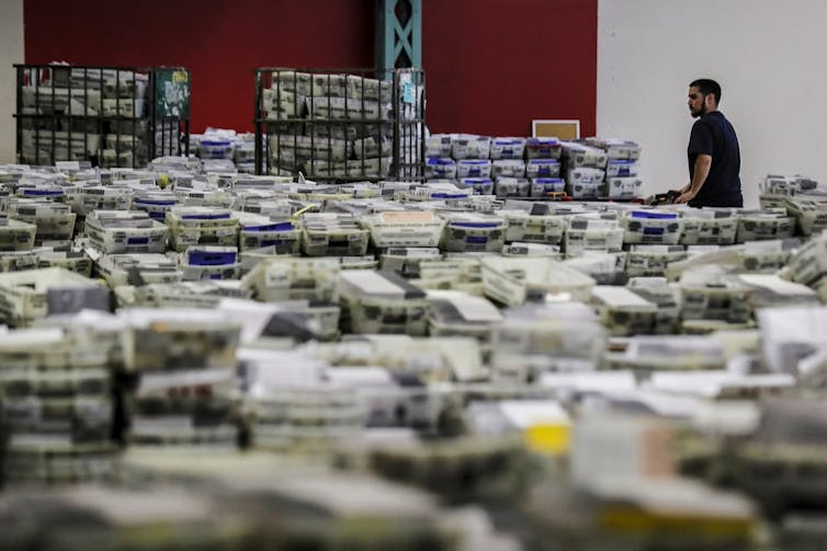 Many boxes of ballots spread across a large room.