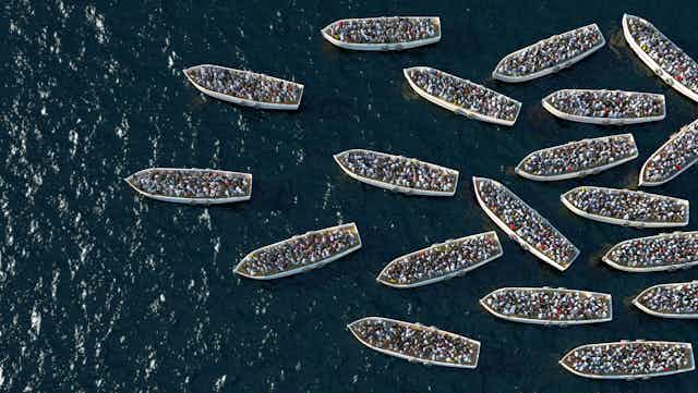 Small boats filled with people on the ocean